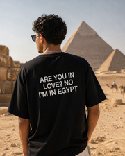 Person wearing a black t-shirt with text at the Giza Pyramids