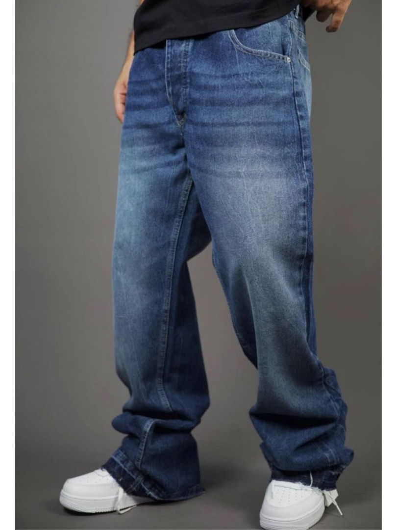 Person wearing blue jeans and white sneakers on a gray background