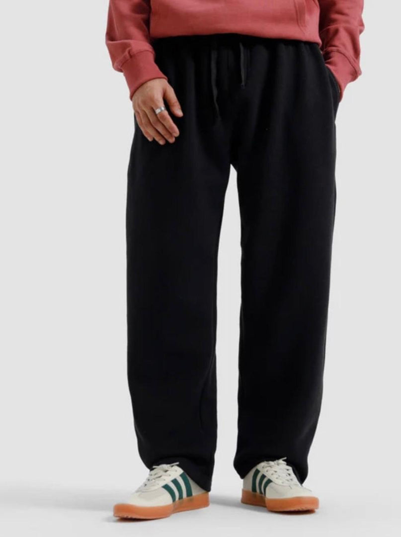 Person wearing black pants and a pink sweatshirt on a white background